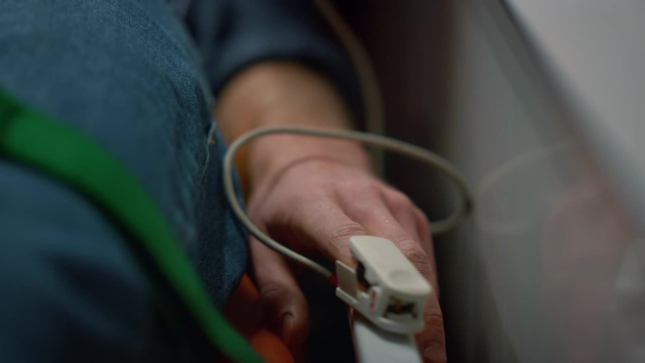 一名男子在救护车上用血氧计检查病人血氧水平视频素材