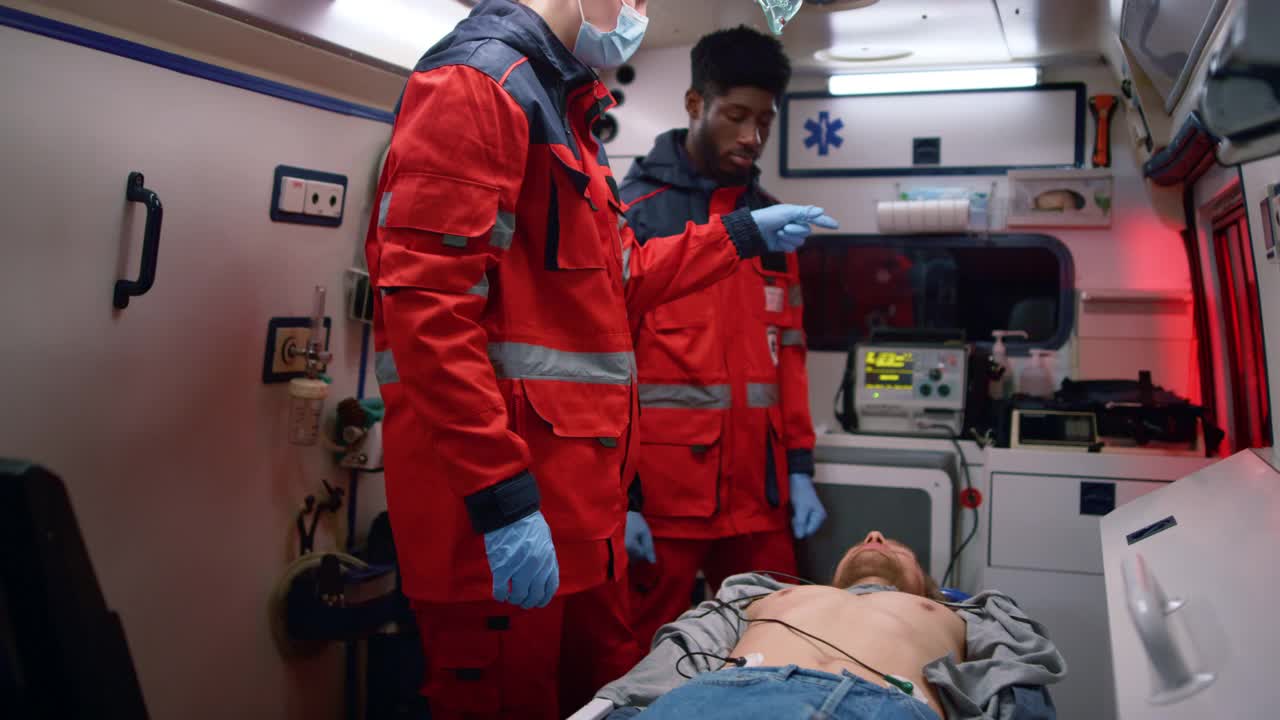 多民族医护人员在急救车中对男子进行急救视频下载