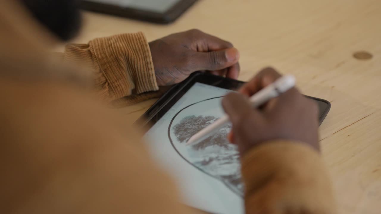 在数码平板电脑上设计瀑布纹身的人视频素材