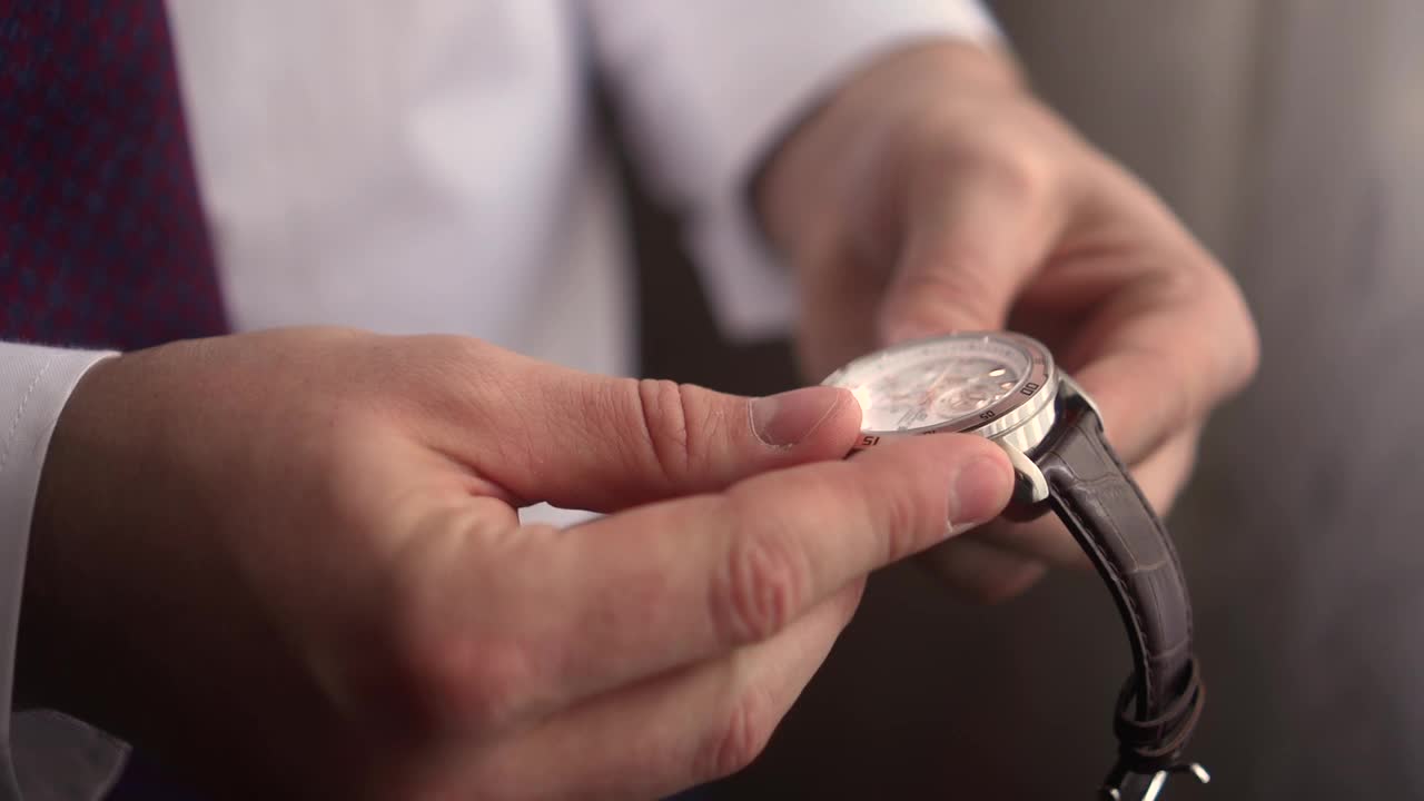 一个男人把手表戴在手上视频下载