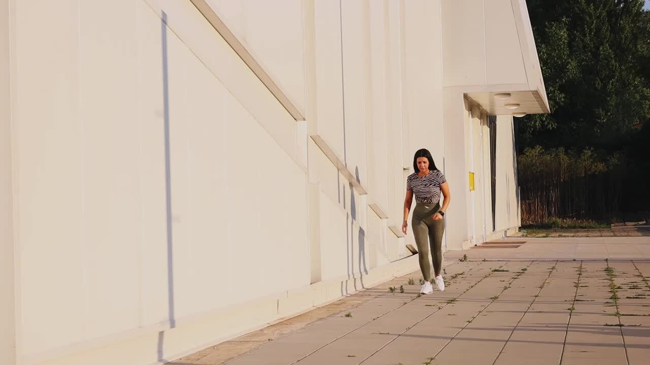 一个阳光明媚的日子，一个年轻女子在附近慢跑视频下载