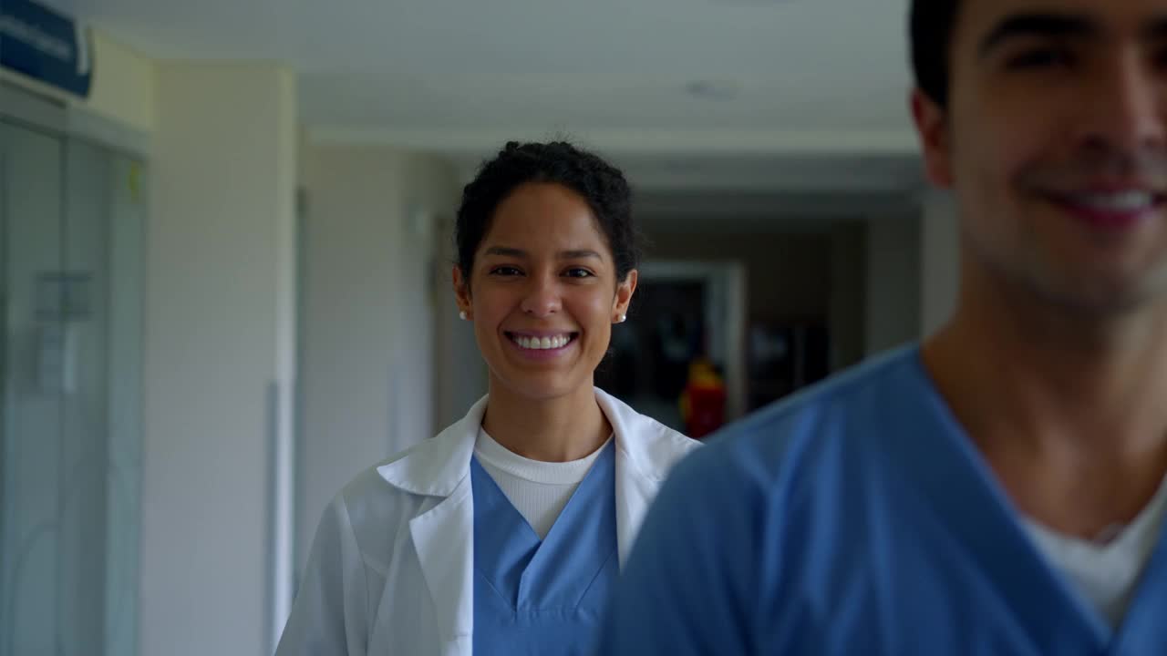 在走廊的医院里，不同专业的医护人员排成一队，对着镜头微笑视频素材