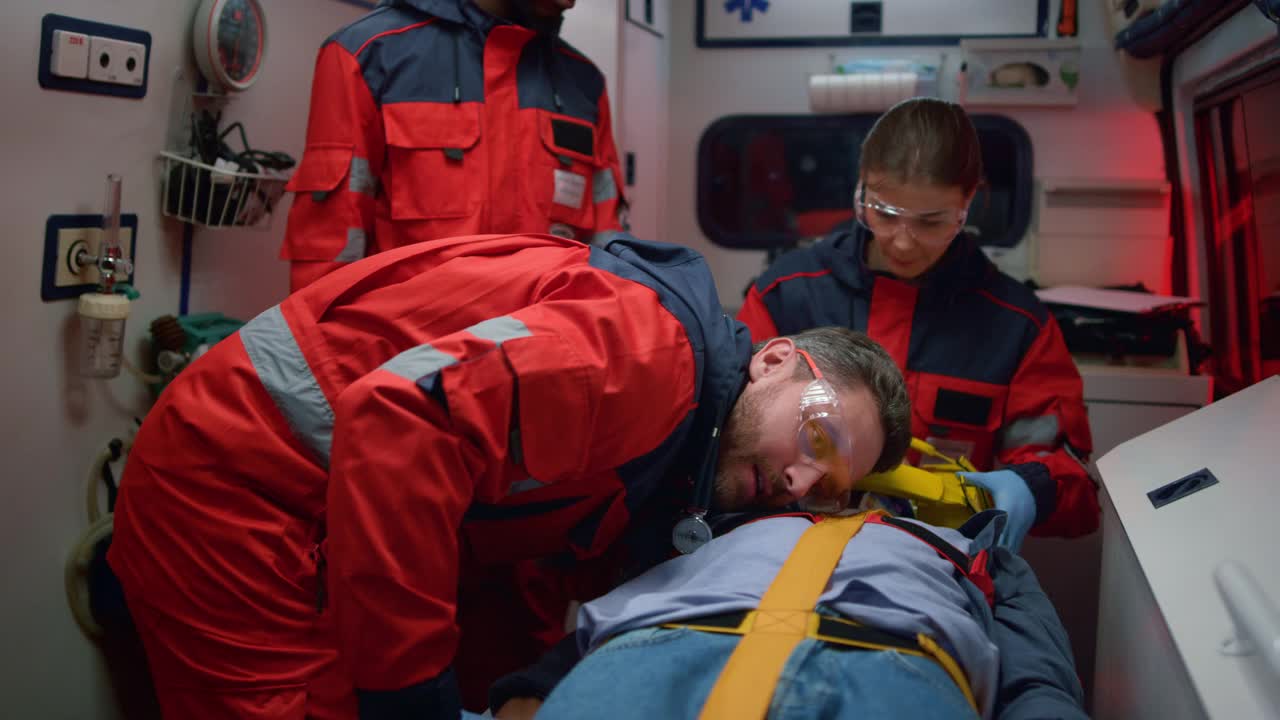 紧急医疗护理人员在急救车中为病人提供急救程序视频下载