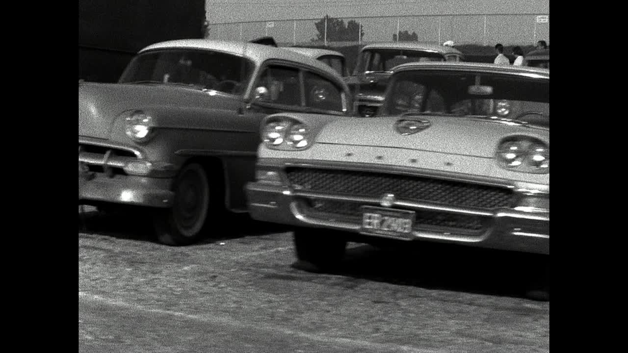 沿着路走过去，经过停在路边的一群老式美国汽车;1961视频下载