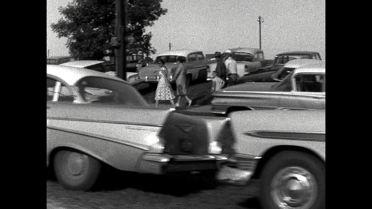 沿着路走过去，经过停在路边的一群老式美国汽车;1961视频下载