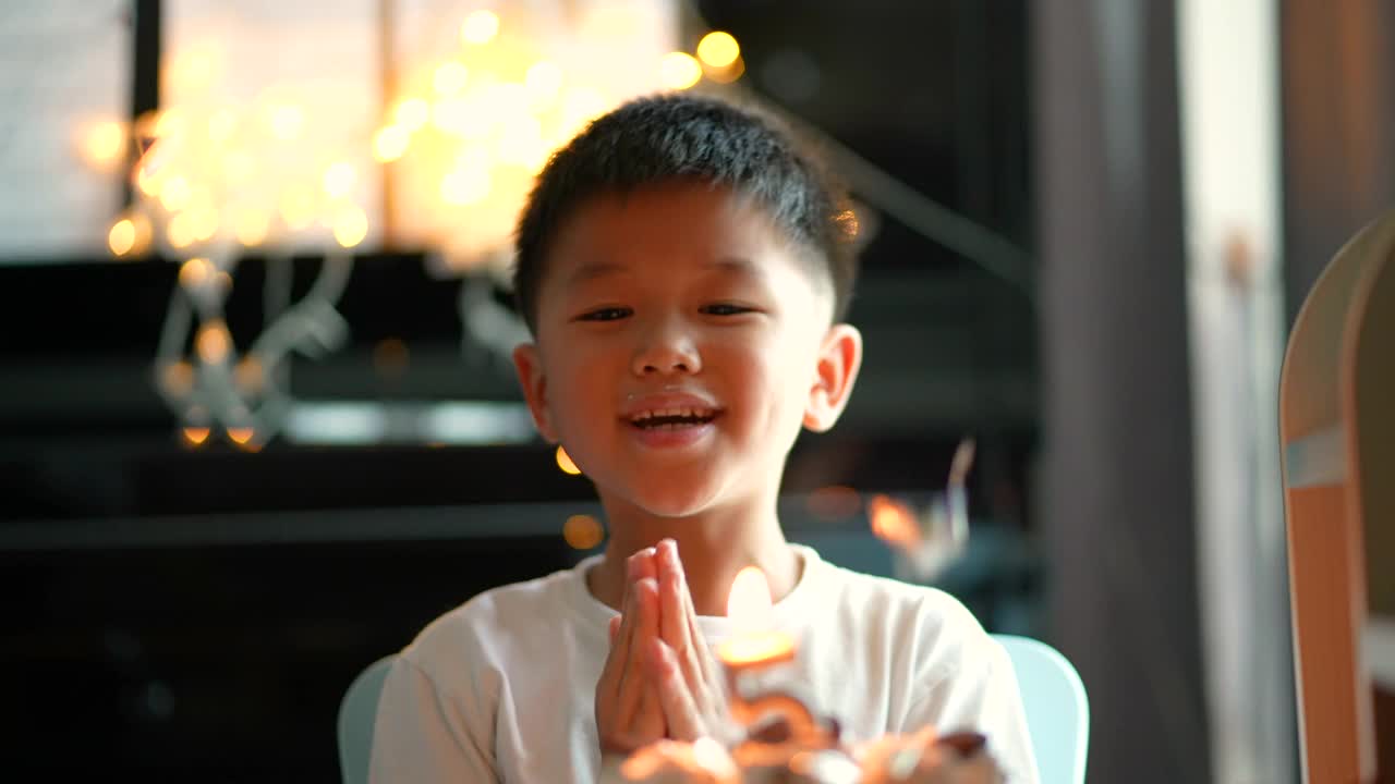 亚洲小孩拿着生日蛋糕和礼物。庆祝和欢乐的概念视频素材