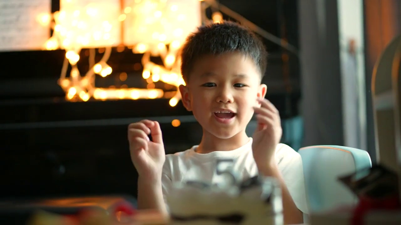 亚洲小孩拿着生日蛋糕和礼物。庆祝和欢乐的概念视频素材