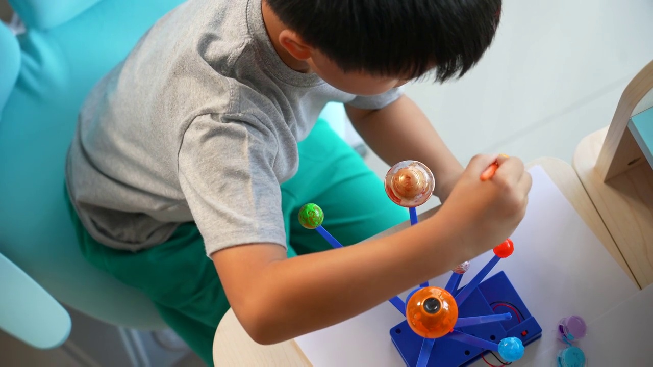 亚洲男孩画太阳系模型。创造性和学习的概念视频下载