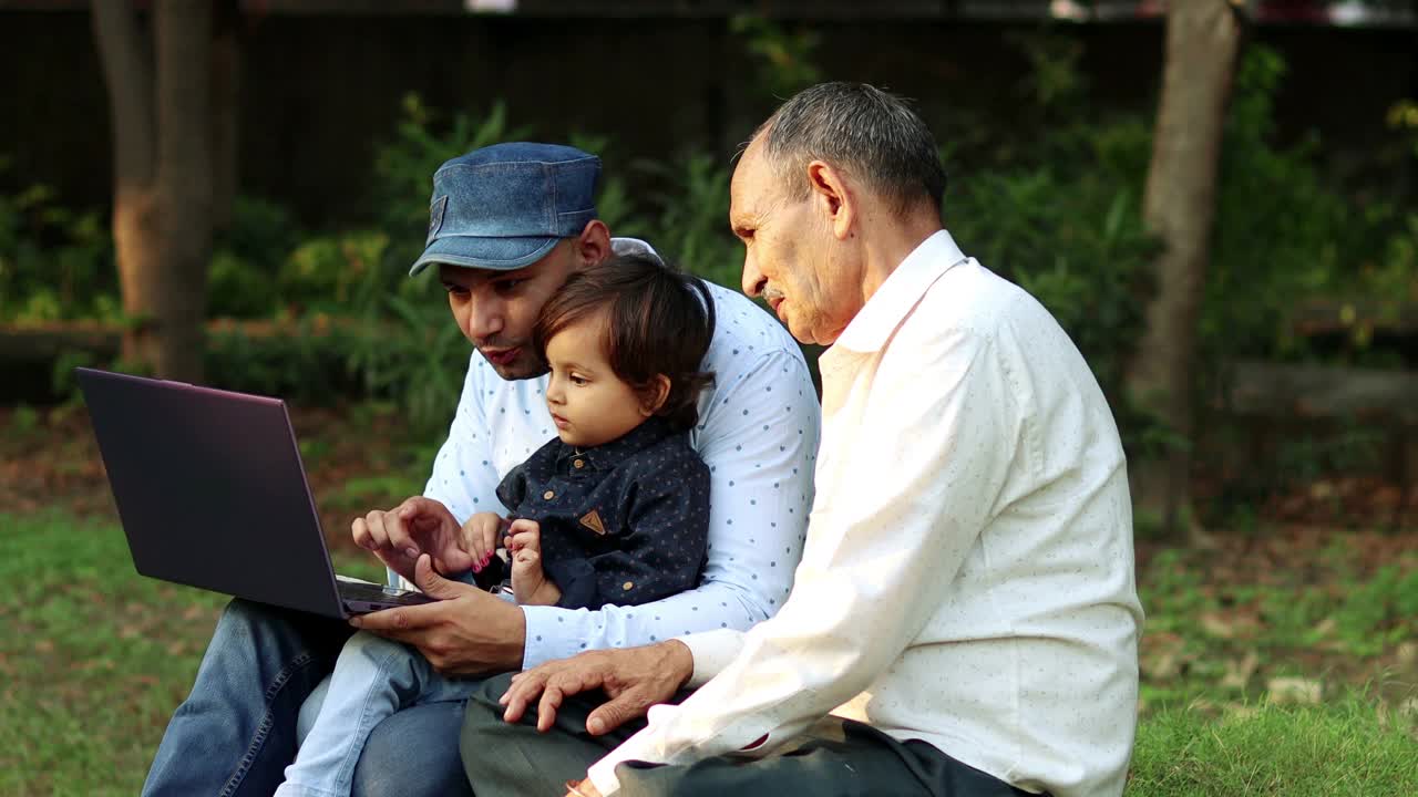 父亲和可爱的孩子在户外使用笔记本电脑视频素材