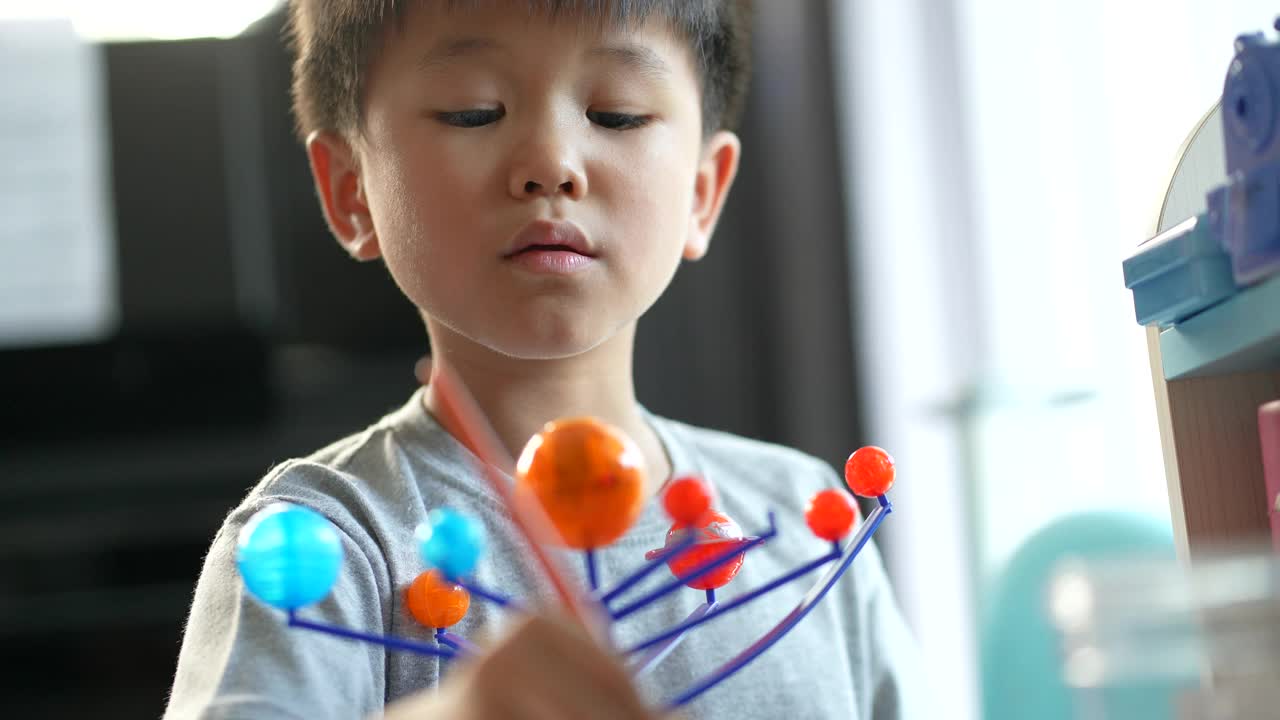 亚洲男孩画太阳系模型。创造性和学习的概念视频下载