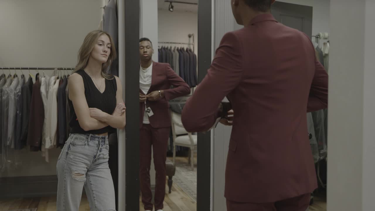 美国犹他州普罗沃一家服装店里，一位女士正在欣赏一位男士试穿西装外套视频下载