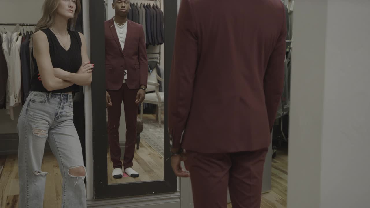 美国犹他州普罗沃一家服装店里，一位女士正在欣赏一位男士试穿西装外套视频下载