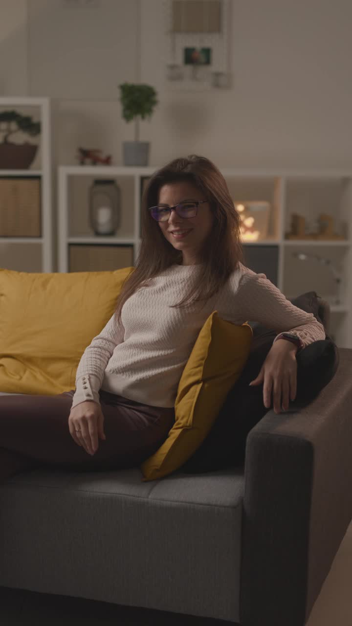 视频肖像的女人坐在客厅沙发上视频下载