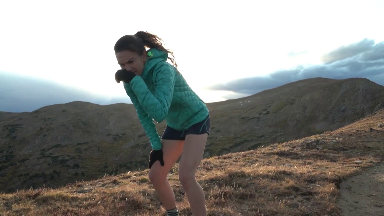 一个女人在山野跑步后休息。视频下载