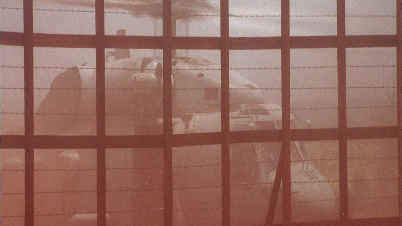 美国军用sh-60b海鹰直升机准备起飞的广角。从有刺铁丝网的篱笆后面。空气中弥漫着红色的灰尘。视频下载