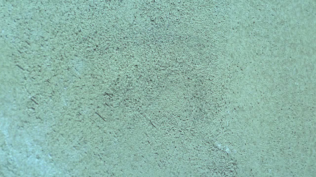 白色灰泥墙的近角。见一大块铅被用来在墙上画抽象的图像。视频下载