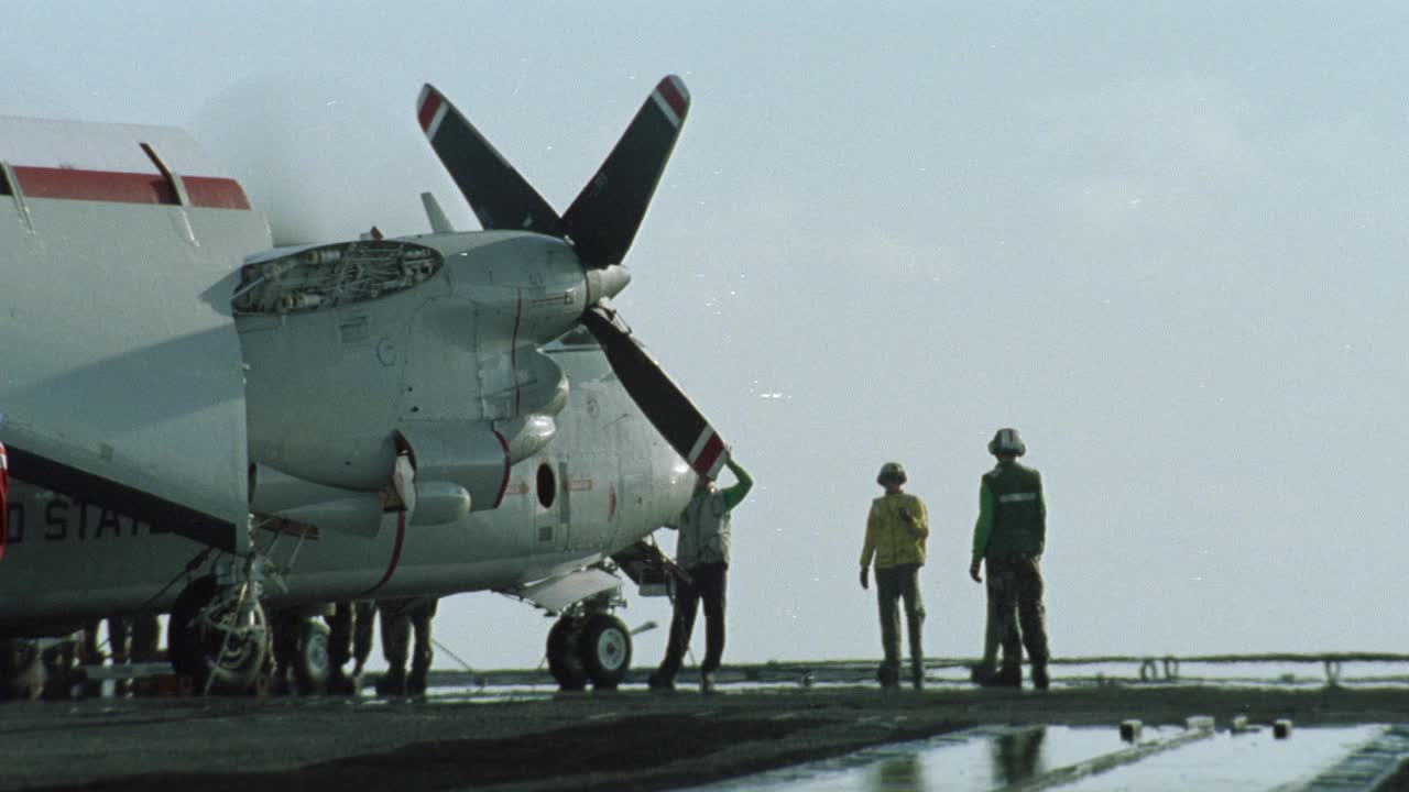 宽角度c-2a灰狗或军用飞机与螺旋桨在跑道上。飞行甲板船员。哈利·s·杜鲁门号航空母舰(cvn-75)。航空母舰。视频素材