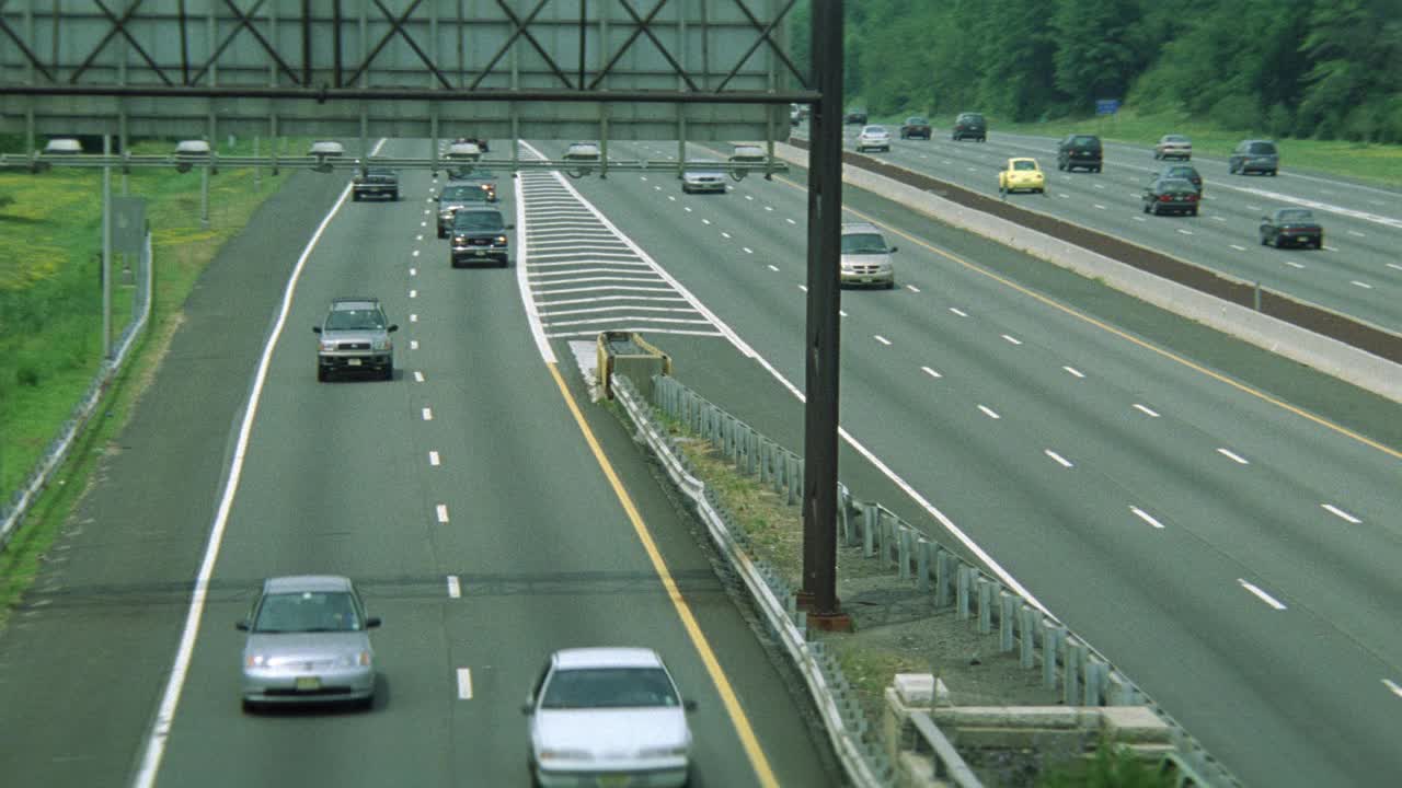 在六车道高速公路或高速公路上，在高速公路立交桥的双车道下匝道上，汽车在双向无车流的情况下自由行驶。波夫在天桥和高速公路的另一边旋转了180度。Pov跟踪路虎在ov下行驶视频素材