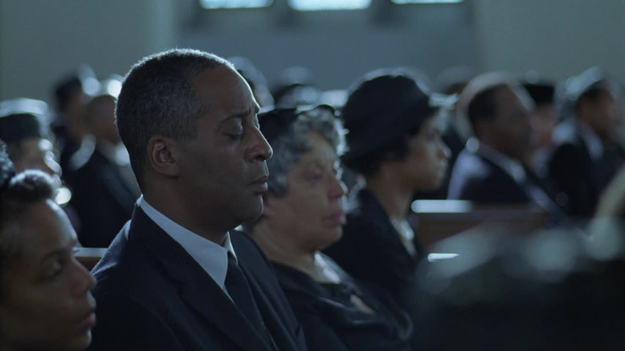 葬礼参加者的特写，人们坐在教堂的长椅上，穿着黑色的衣服。悲伤,悲伤,悲伤。视频下载