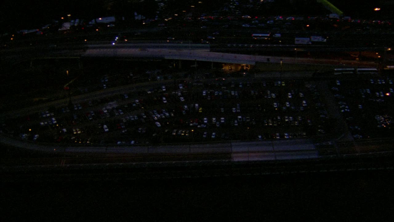 高速公路或高速公路的空中架空，旁边的停车场挤满了汽车。镜头移向老洋基体育场。正在进行棒球比赛。体育场的灯光和观众。纽约洋基队。城市。视频素材