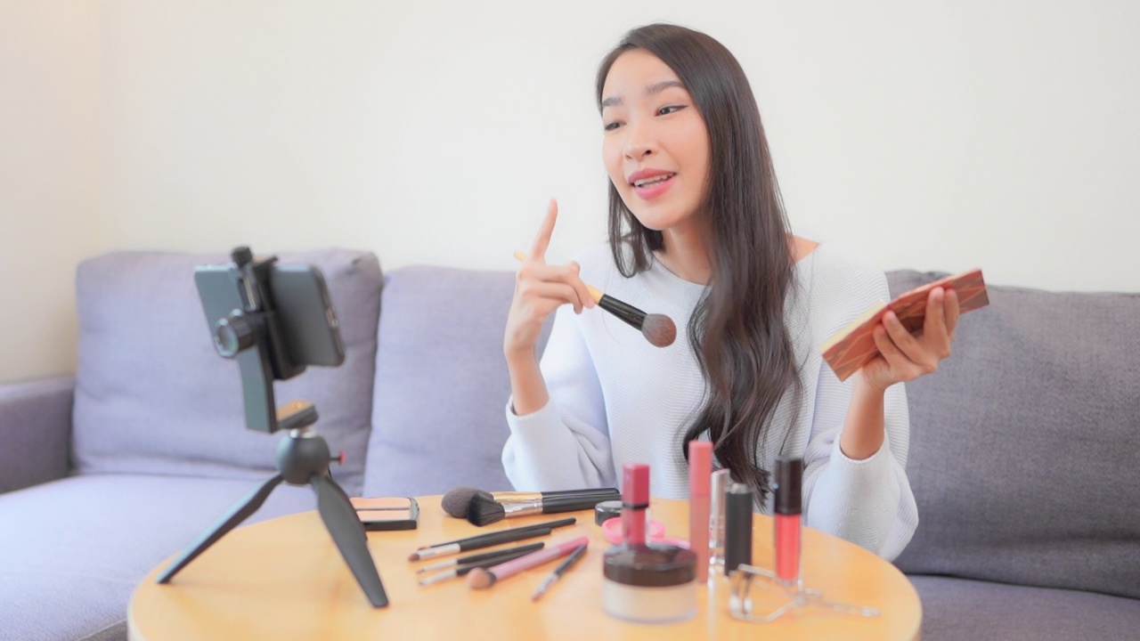 年轻的亚洲女性在网上评论化妆品视频下载