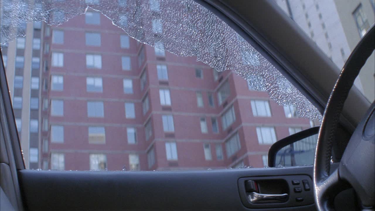 近角度破碎的司机的侧窗在汽车或越野车。破碎的窗户和玻璃。方向盘和侧视镜。bg的公寓大楼。视频素材