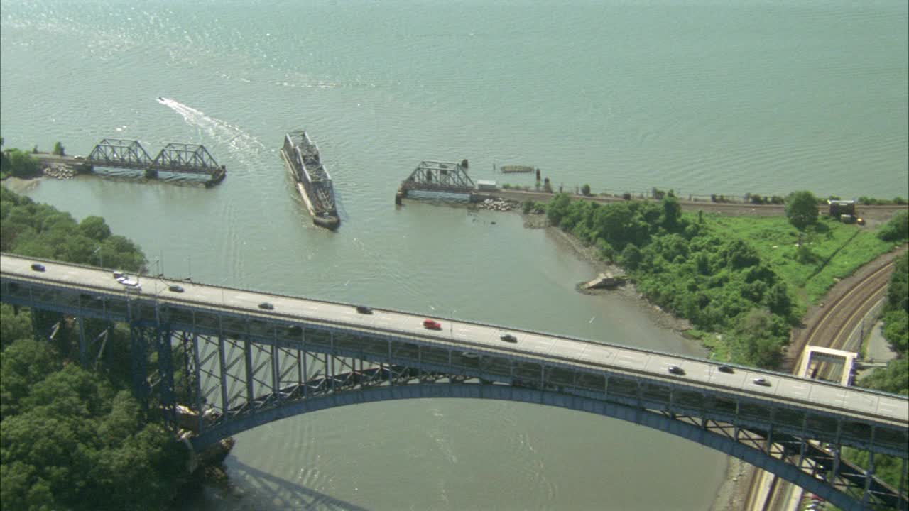 亨利·哈德逊大桥连接布朗克斯和曼哈顿。汽车驶过亨利·哈德逊公园大道上的大桥。SPUYTEN DUYVIL小溪。树下面。可能是河。视频素材