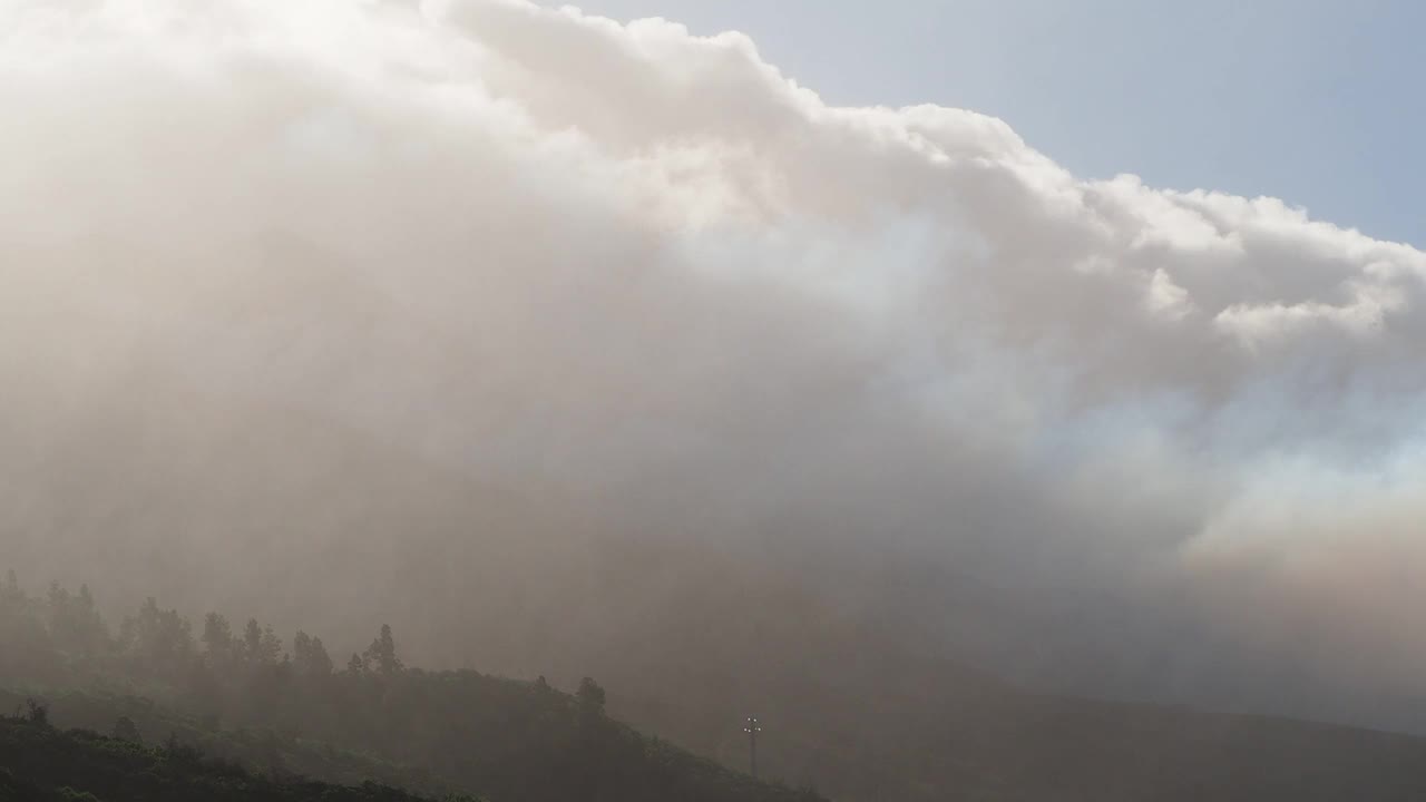 火山灰云和火山烟雾沿着火山喷发的斜坡下降。俯瞰康伯维哈火山，浓烟和熔岩柱从主锥中喷出。视频素材