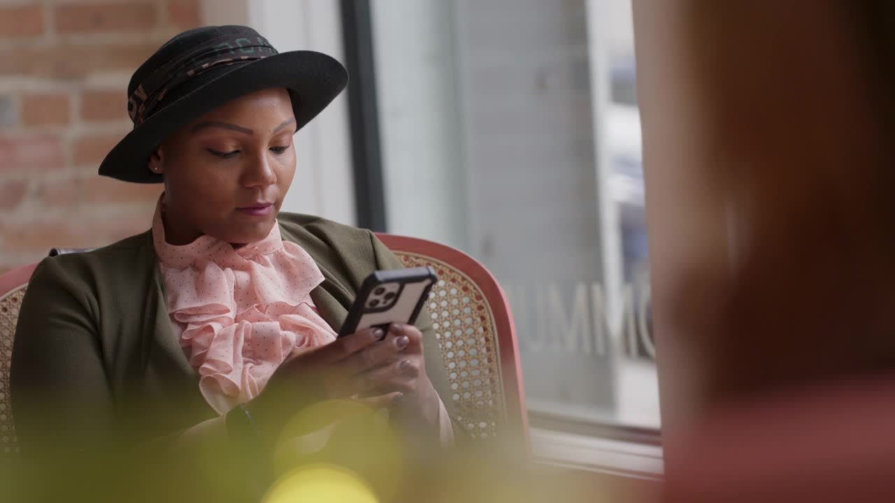 时尚女性一边用智能手机看窗外视频素材