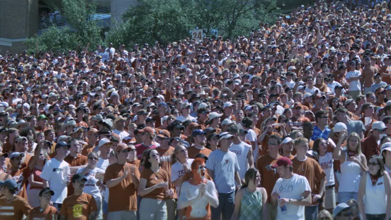 中角德克萨斯大学的球迷或观众站在燃烧的橙色体育场。体育馆的灯光。足球比赛。达雷尔k.皇家体育场。人群欢呼。视频素材