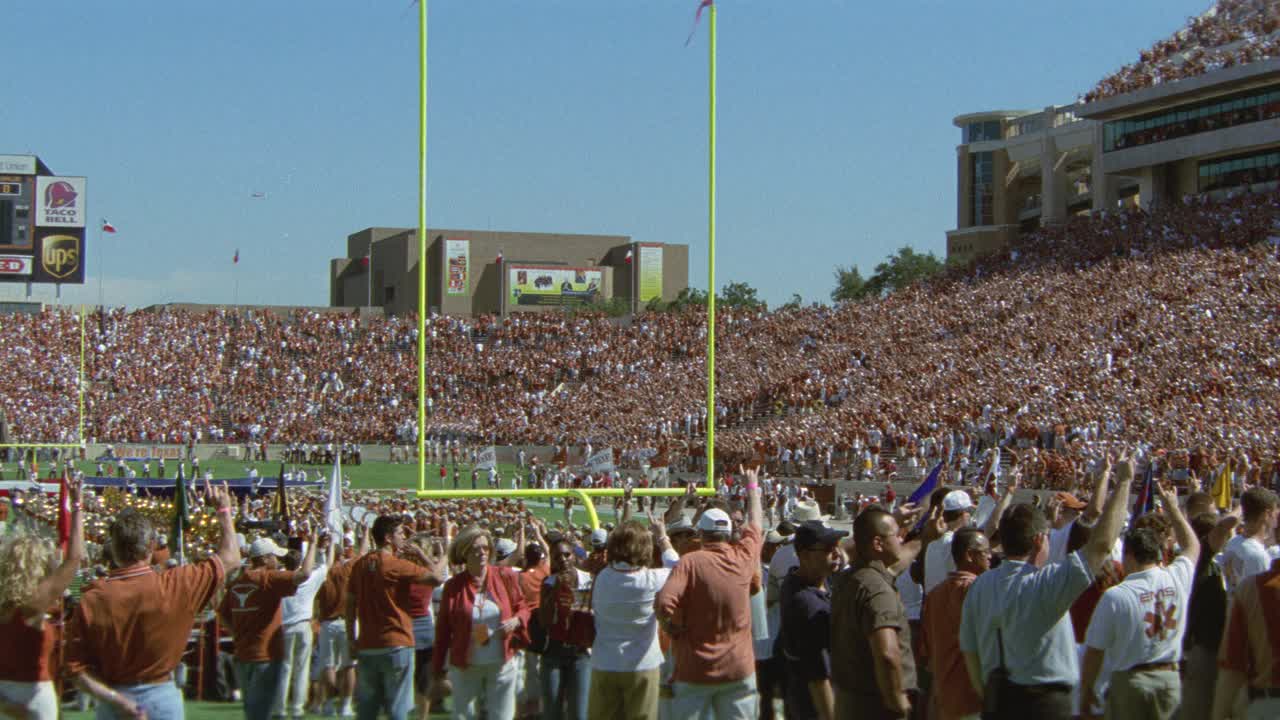 广角观众站在球场上的德克萨斯大学橄榄球比赛。在看台上欢呼的观众。达雷尔k.皇家纪念体育场。足球队在球场上。触地得分。投篮得分门柱。视频素材