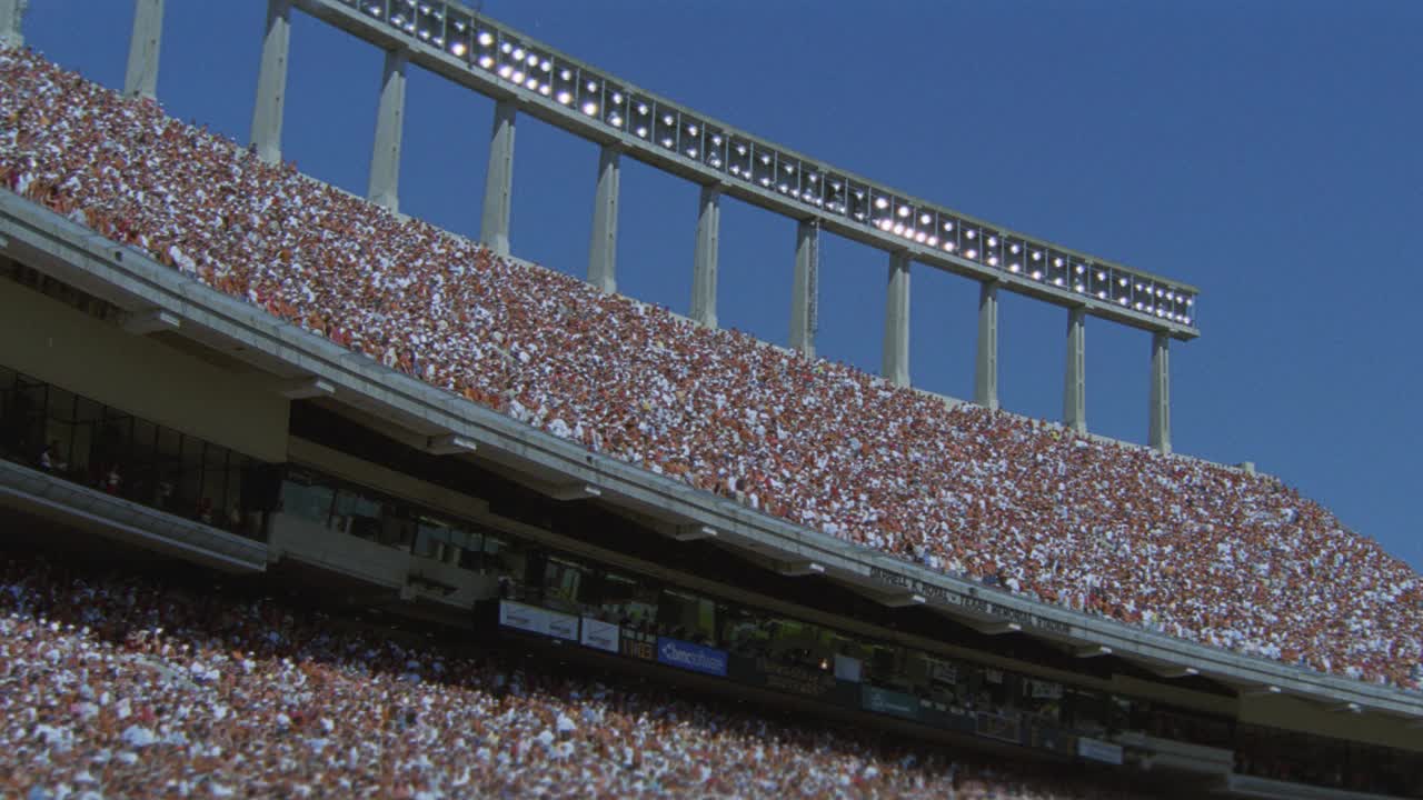 观看德克萨斯大学橄榄球比赛的观众或球迷在体育场欢呼的角度。达雷尔k.皇家纪念体育场。人群的欢呼声。体育馆的灯光。视频素材