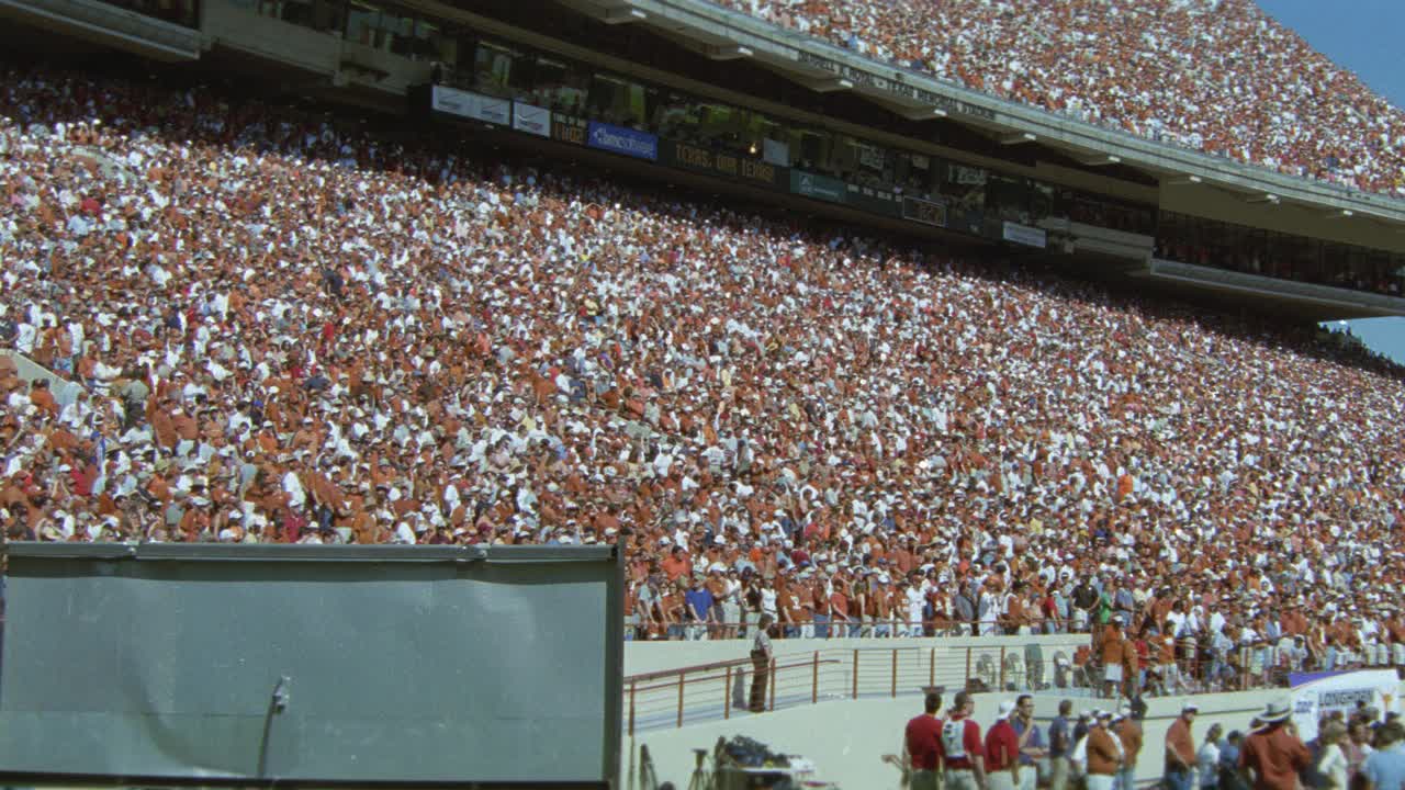 广角观众或球迷在体育场欢呼德州大学的橄榄球比赛。达雷尔k.皇家纪念体育场。人群的欢呼声。视频素材