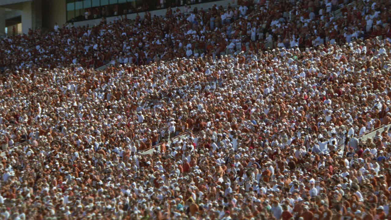 广角观众或球迷在体育场欢呼德州大学的橄榄球比赛。达雷尔k.皇家纪念体育场。人群的欢呼声。视频素材