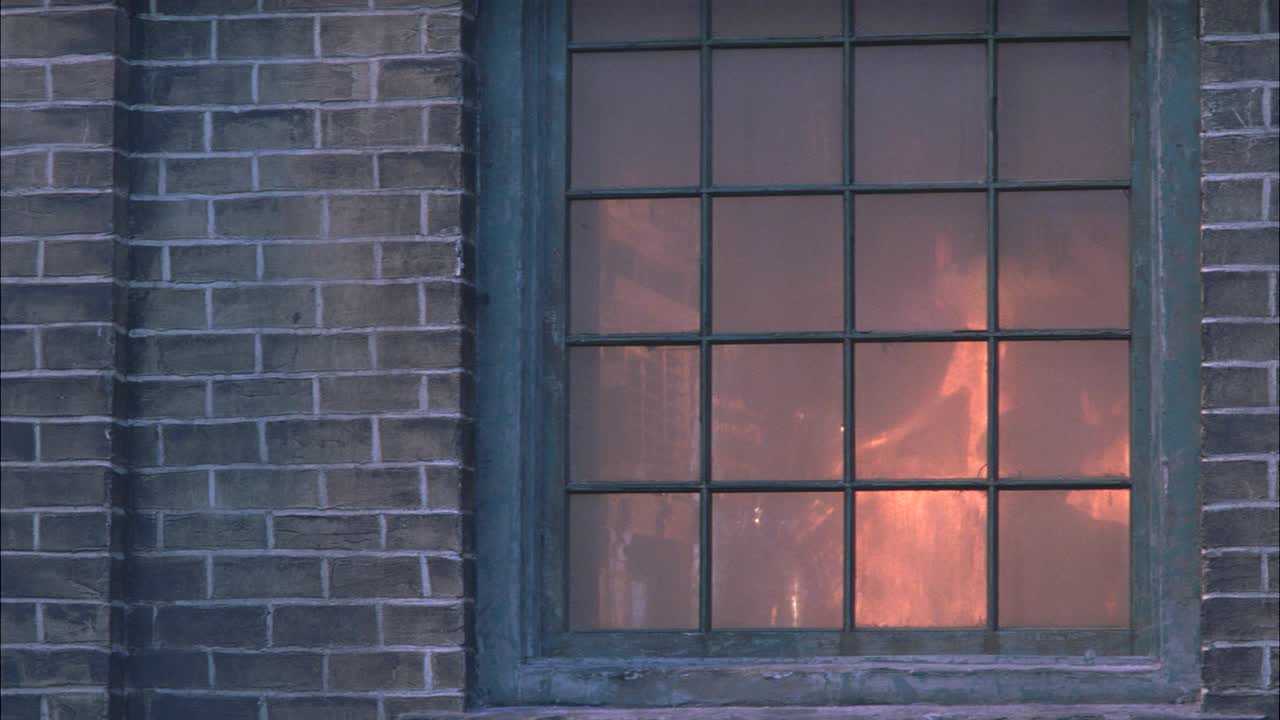中景拍摄的是一名男子，后面跟着一名女子和一名戴牛仔帽的男子，在爆炸前从砖房窗户逃走。火，火焰和烟。破窗理论。噱头。48 FPS。视频下载