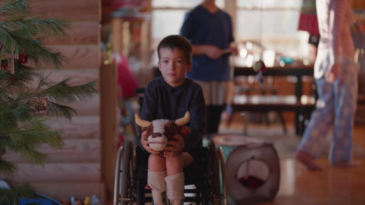 圣诞早晨，一个坐在轮椅上的男孩的肖像视频素材