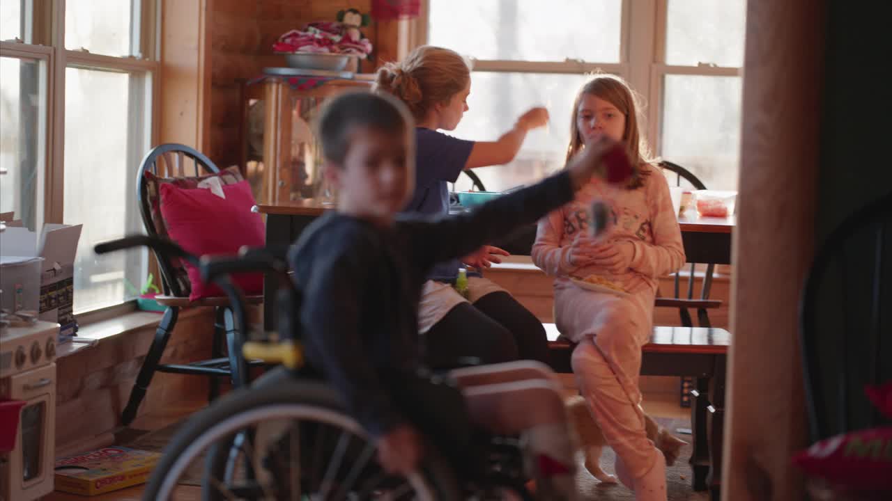 圣诞节早上，坐在轮椅上的男孩玩球视频素材