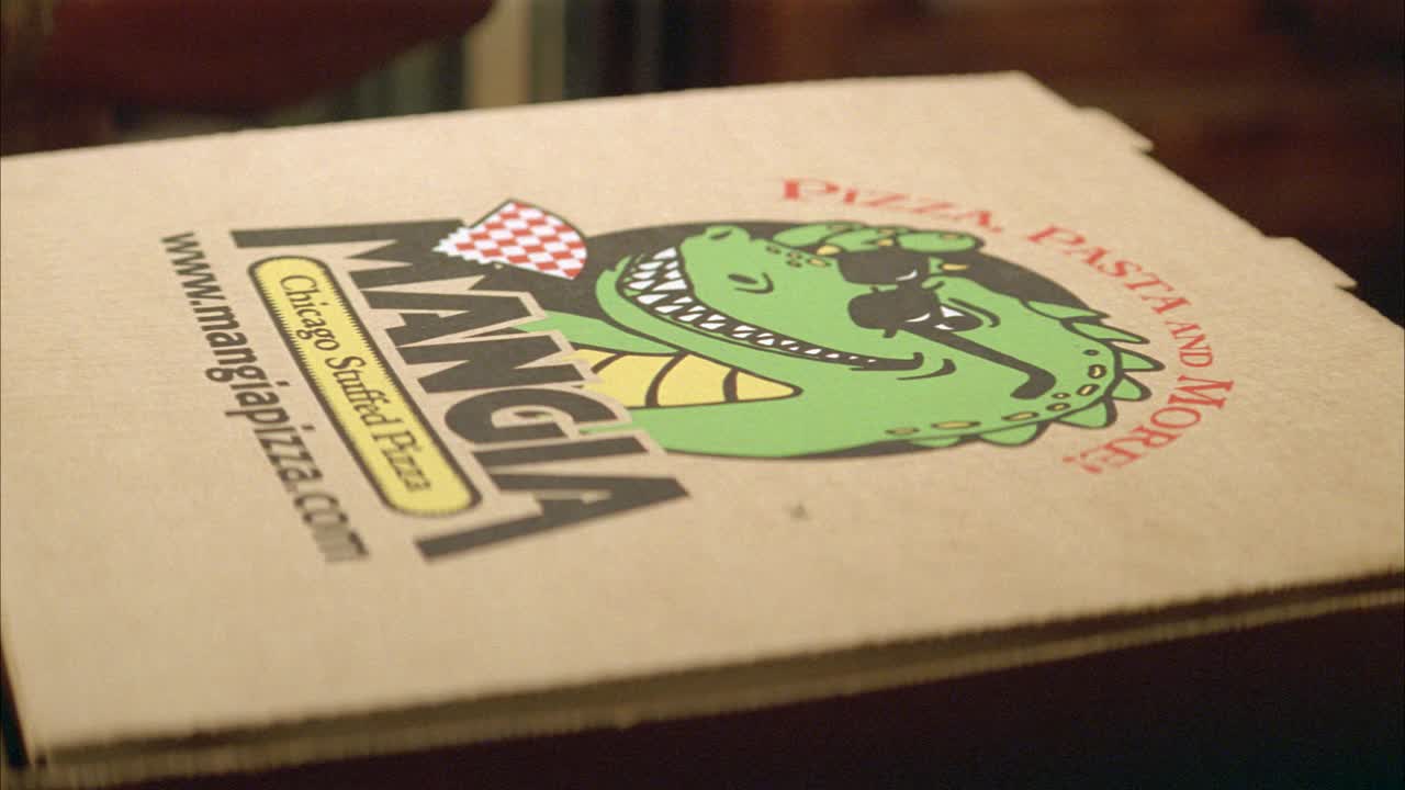 一个男人的手打开一个盒子，露出一个深盘披萨，肉，奶酪和墨西哥胡椒的特写镜头。这个人拿起披萨派，把它放在桌子上，开始切。快餐。视频下载