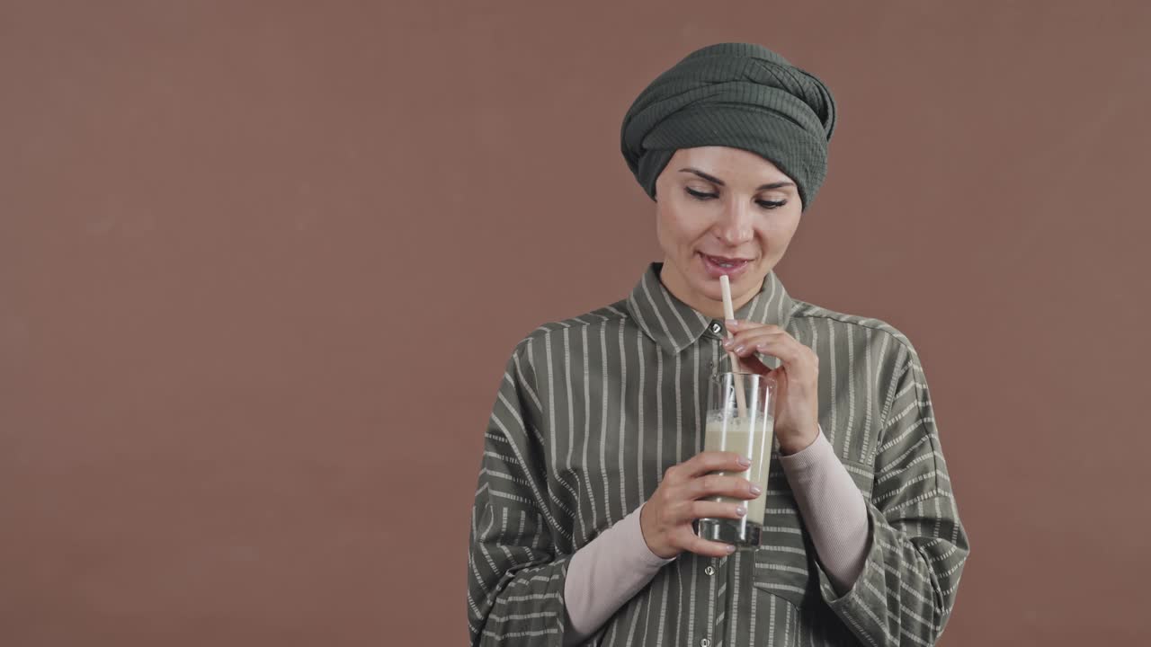 快乐的穆斯林妇女喝冰沙和微笑的肖像视频素材