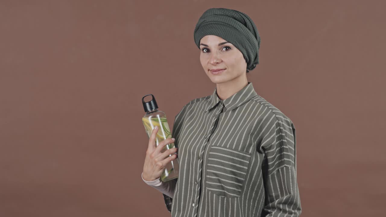 积极的穆斯林妇女与健身包和水瓶在工作室视频素材