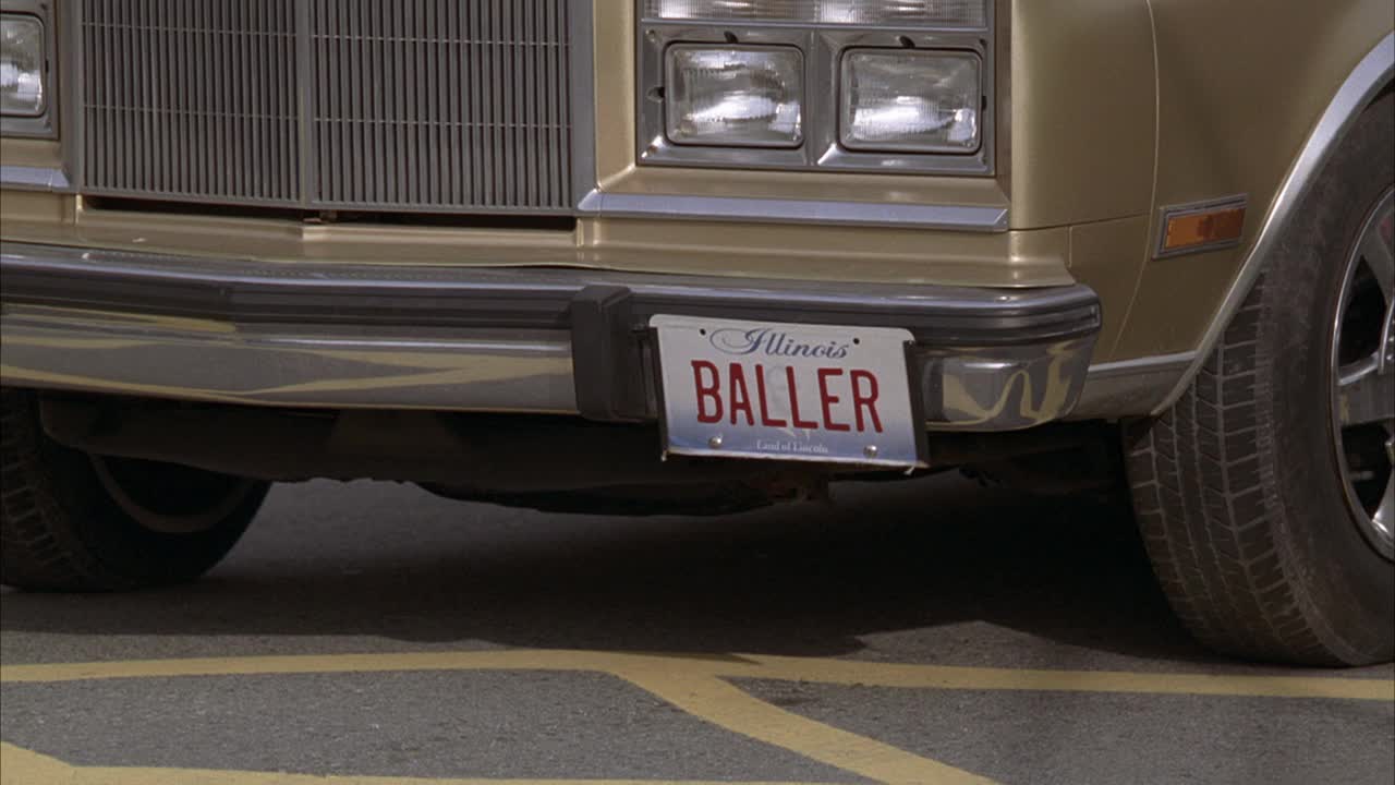 近距离观察伊利诺斯州的车牌，上面写着"球手"1988年克莱斯勒第五大道。车拉的方式。轮胎可见。视频下载