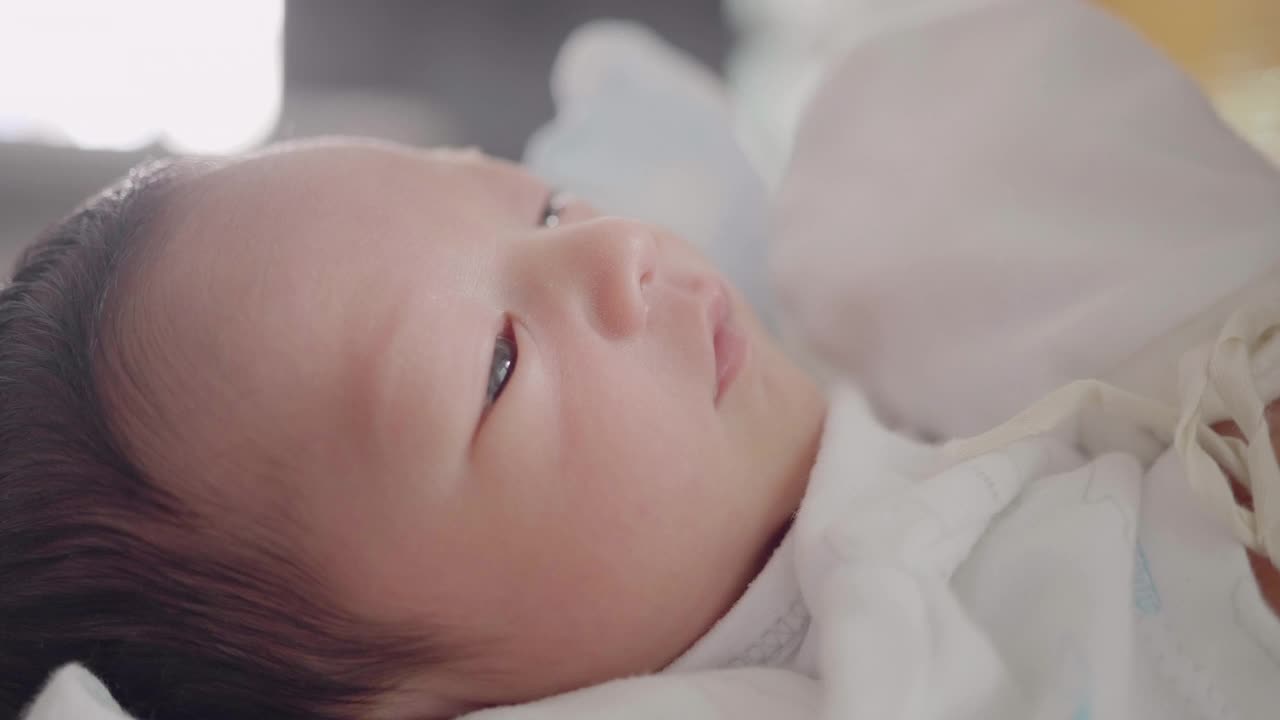 靠近宝宝的脸，亚洲妈妈准备给0-1个月的宝宝换尿布。视频下载