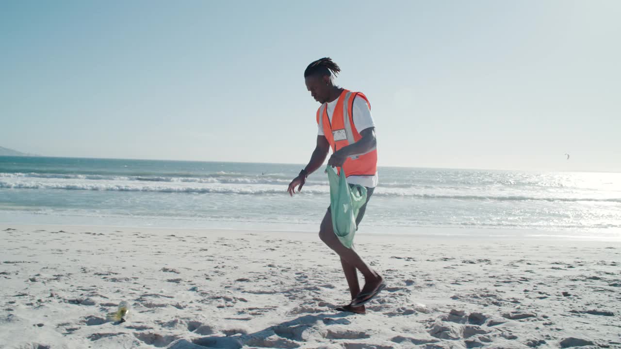 一个年轻人在沙滩上捡垃圾的4k视频视频下载