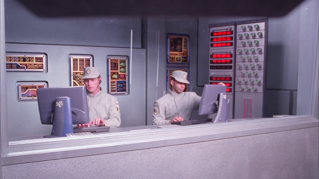 广角的未来控制室由两个警卫或人员，谁是打字的电脑键盘。摄像机右移至相邻房间地板上的警告标志。视频素材