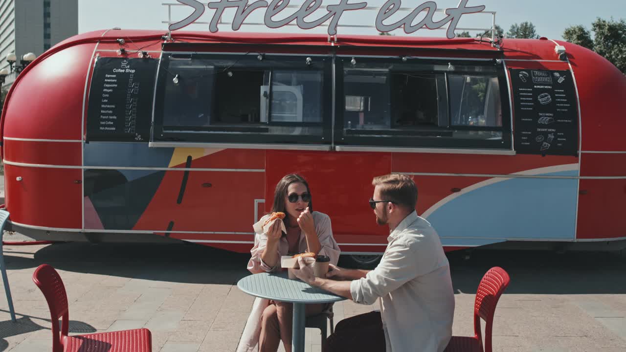 夏天的情侣们在街上吃着小吃，在户外聊天视频下载
