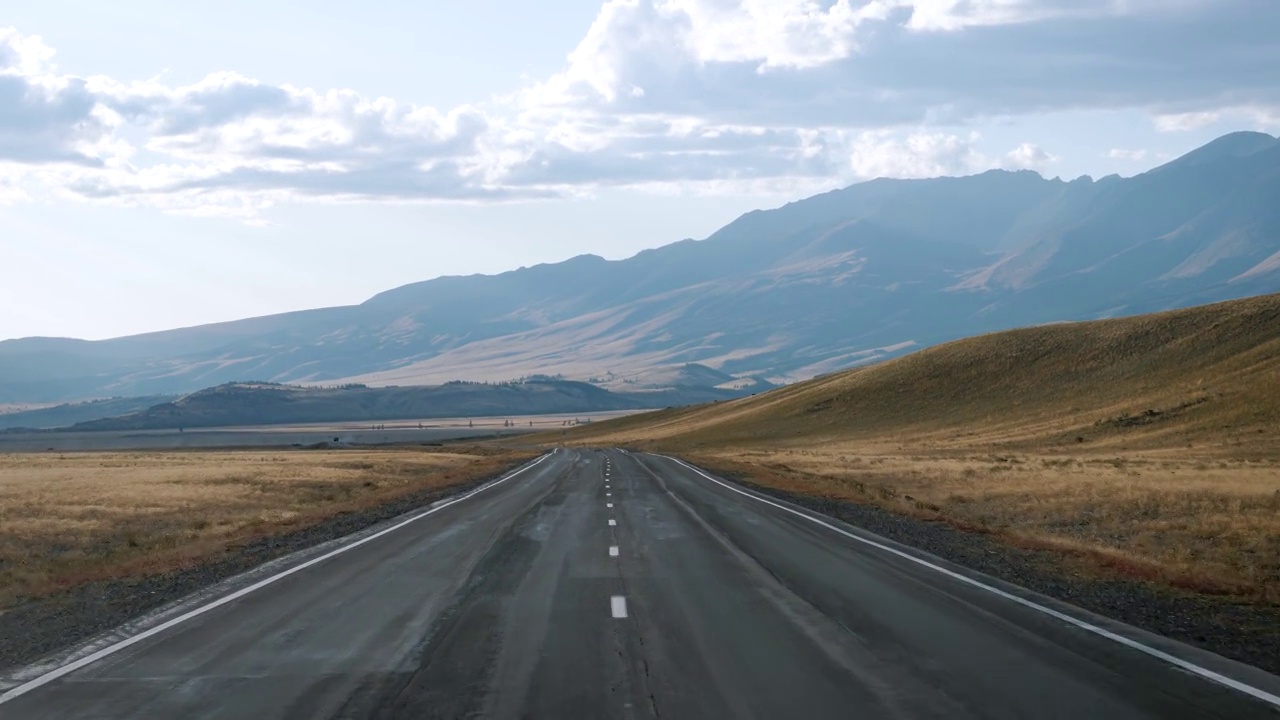 在丘陵和干燥的沙漠中，在空无一人的公路上开车视频下载