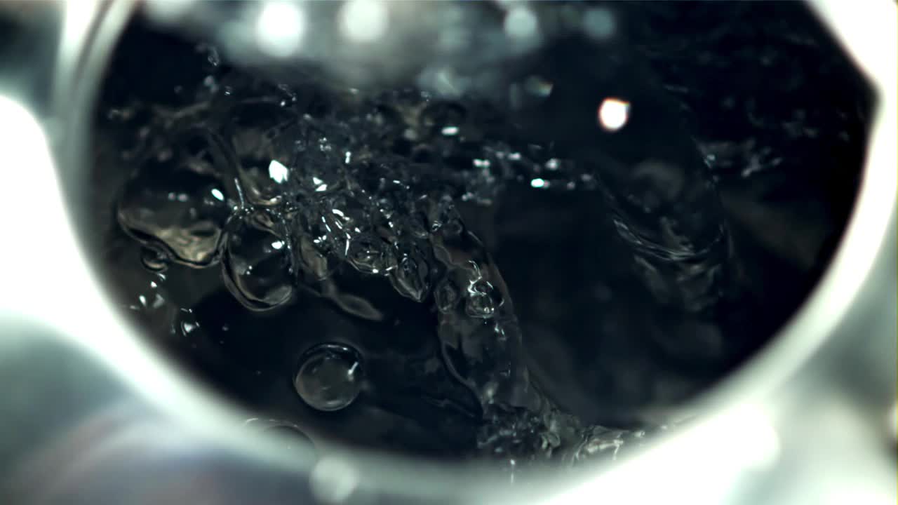 有气泡的热水倒进杯子里。拍摄的是慢动作每秒1000帧。视频素材