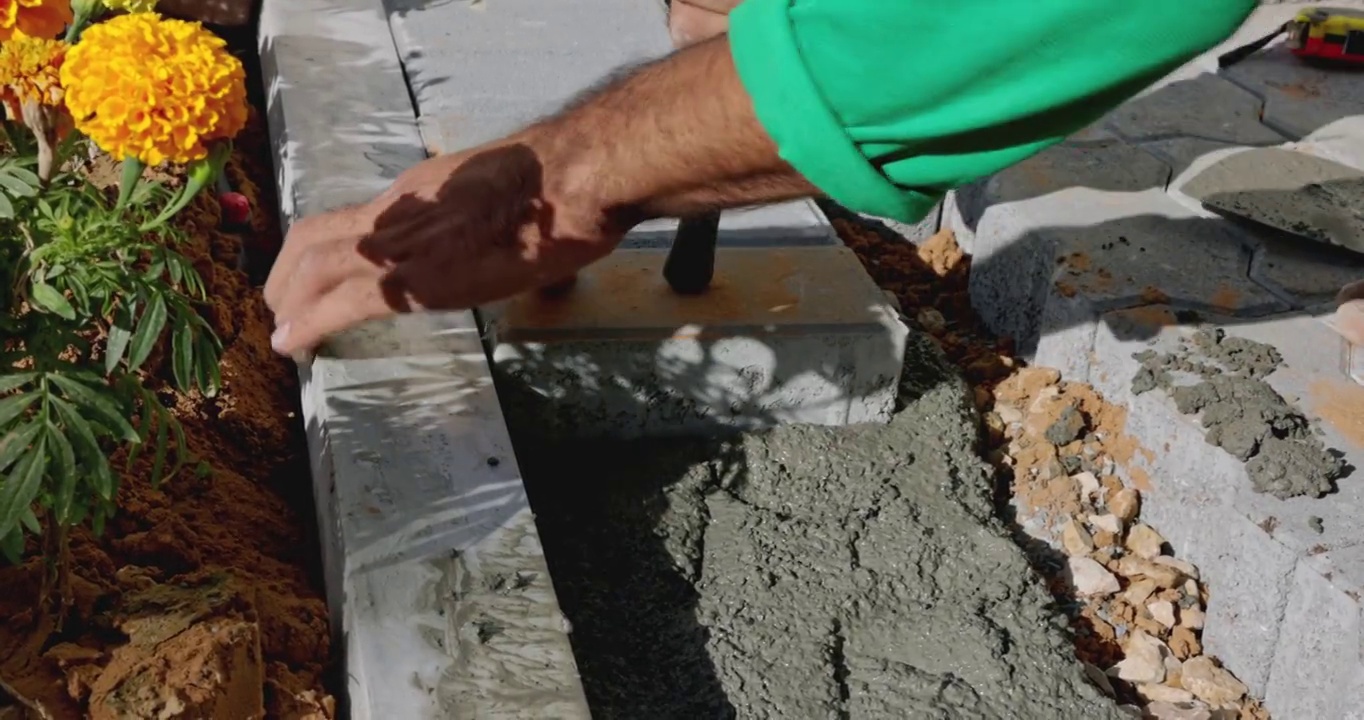 将水泥砖铺在混凝土混合物上的石匠视频下载
