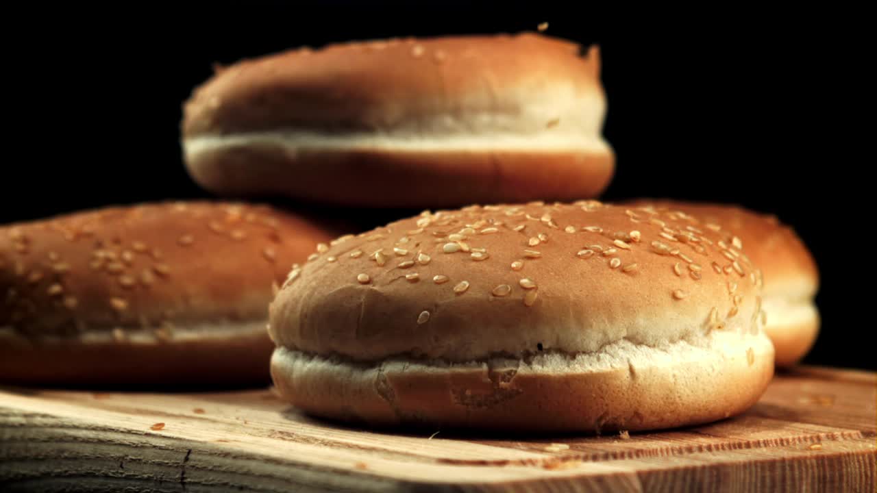 芝麻掉在汉堡面包上。拍摄的是慢动作每秒1000帧。视频下载