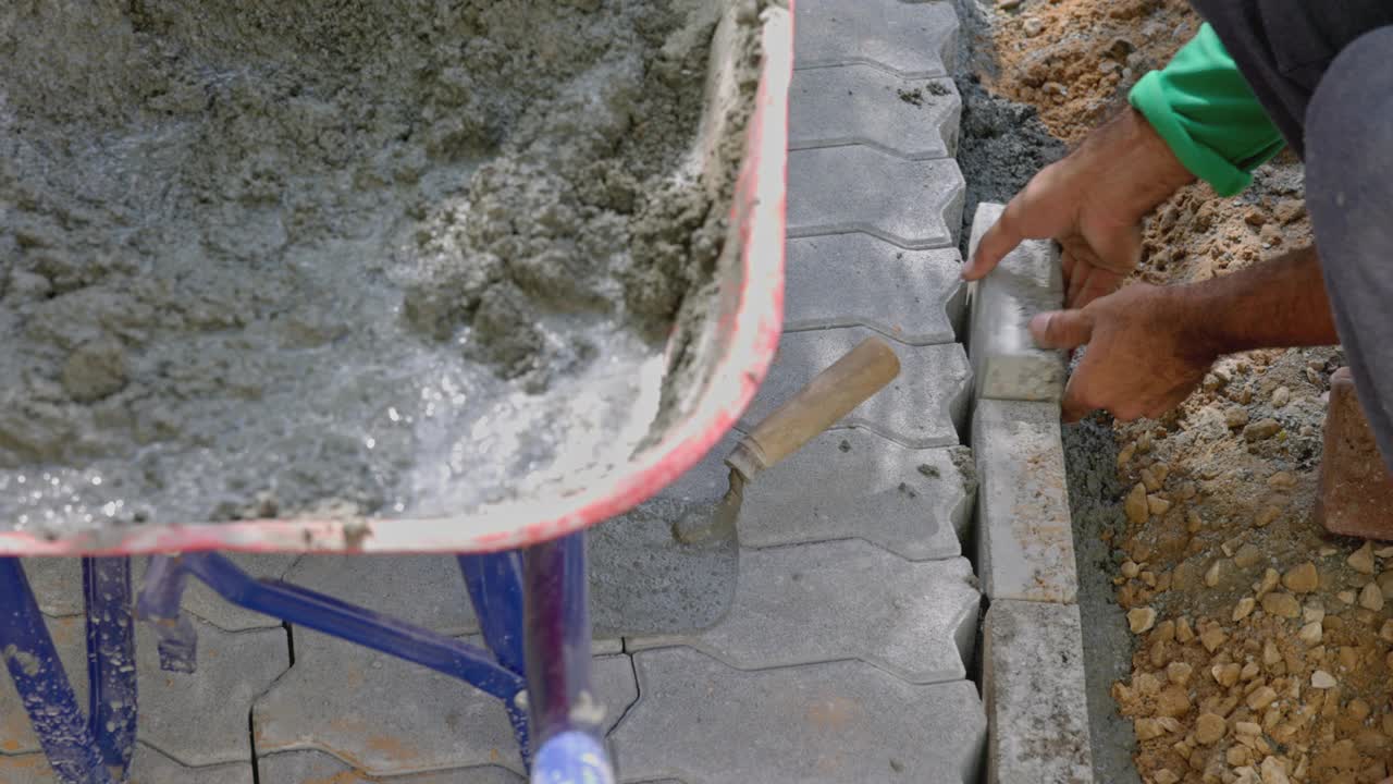 石匠在混凝土混合物上对齐水泥砖视频下载